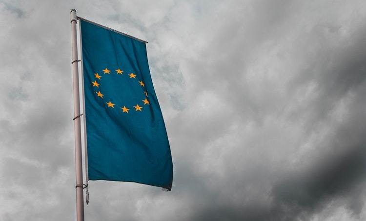 European Union flag against a dark, stormy sky background